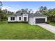 Single-story home with gray roof, white siding, and a two-car garage at 5557 Rosette Rd, North Port, FL 34288