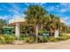 Park entrance featuring covered drop-off and information signage, framed by palm trees and landscaping at 929 Suncrest Ln, Englewood, FL 34223