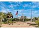 View of flags flying at a Veteran's Memorial in a park setting, surrounded by palm trees at 929 Suncrest Ln, Englewood, FL 34223