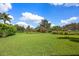 Expansive grassy lawn with mature landscaping at 3525 Founders Club Dr, Sarasota, FL 34240