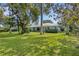 Ranch home with lush lawn, mature trees, and a metal roof at 2403 Palma Sola Blvd, Bradenton, FL 34209