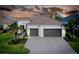 Two-story house with brown tile roof and two-car garage at sunset at 284 Corelli Dr, Nokomis, FL 34275