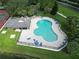 Overhead shot of the community pool surrounded by lush landscaping, lounge chairs and a secure fence at 4938 72Nd E Ct, Bradenton, FL 34203