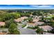 Scenic aerial view of a quiet residential neighborhood with lush greenery and well-maintained homes, and distant views of the water at 2128 Waweep Ct, Sarasota, FL 34235