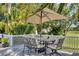 Outdoor patio with seating area, umbrella, and lush landscaping at 6414 Glen Abbey Ln, Bradenton, FL 34202