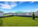 Green backyard with view of under construction homes at 10109 Spruce River Way, Parrish, FL 34219