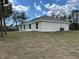 Exterior view of the home's backyard and stucco siding under sunny skies at 1010 Huntington St, North Port, FL 34288