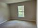 Bright and airy bedroom with carpet and a view of trees through the window at 1010 Huntington St, North Port, FL 34288