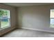 Bright bedroom with neutral carpet, base trim and large windows with backyard views at 1010 Huntington St, North Port, FL 34288