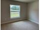 Bright bedroom with neutral carpet and a large window overlooking the neighborhood at 1010 Huntington St, North Port, FL 34288