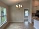 Open dining area with modern chandelier and view of the kitchen and living area at 1010 Huntington St, North Port, FL 34288