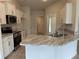 Modern kitchen with white cabinets, marble countertops, and stainless steel appliances at 1010 Huntington St, North Port, FL 34288