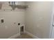 Laundry room includes utility connections and overhead shelving for storage at 1010 Huntington St, North Port, FL 34288