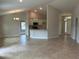 Open-concept living area with tile flooring and a view of the modern kitchen at 1010 Huntington St, North Port, FL 34288