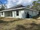 Exterior of light green home featuring a patio area, well, and verdant green backyard at 5661 Gaffney Rd, North Port, FL 34286
