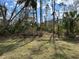 Backyard landscaping featuring mature trees and natural foliage creating a serene outdoor space at 5661 Gaffney Rd, North Port, FL 34286