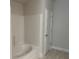 Clean bathroom with a tiled tub and a door at 5661 Gaffney Rd, North Port, FL 34286