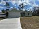 Charming single-story home featuring a two-car garage, a well-manicured lawn, and a light green exterior at 5661 Gaffney Rd, North Port, FL 34286