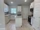 Modern kitchen features white cabinets, stainless steel appliances, granite countertops, and a center island at 5661 Gaffney Rd, North Port, FL 34286