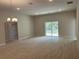 Bright, open-concept living room with recessed lighting and tile floors, flowing towards a sliding glass door at 5661 Gaffney Rd, North Port, FL 34286
