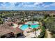 Aerial view of community pool, clubhouse, and surrounding landscape at 323 Winding Brook Ln # 102, Bradenton, FL 34212
