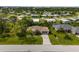 An aerial view of a home with mature landscaping, a long driveway, and a glimpse of the community at 8993 Bantry Bay Blvd, Englewood, FL 34224