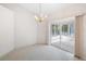An empty dining room with a chandelier and sliding glass doors leading to a bright sunroom at 8993 Bantry Bay Blvd, Englewood, FL 34224