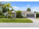 Charming one-story home boasts lush landscaping, vibrant green lawn, and a spacious driveway leading to a two-car garage at 8993 Bantry Bay Blvd, Englewood, FL 34224