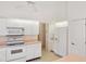 Bright kitchen featuring white cabinetry, modern appliances, and light wood look flooring at 8993 Bantry Bay Blvd, Englewood, FL 34224