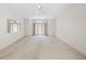 Large, empty living room with a ceiling fan and double doors leading outside at 8993 Bantry Bay Blvd, Englewood, FL 34224