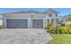 Two-story home with gray double garage and paver driveway at 21285 Holmes Cir, Venice, FL 34293