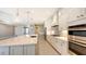 Open concept kitchen with white cabinets, large island, and stainless steel appliances at 21285 Holmes Cir, Venice, FL 34293