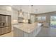 Open concept kitchen with white cabinets, large island, and stainless steel appliances at 21285 Holmes Cir, Venice, FL 34293