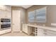 White kitchen cabinets, built-in oven, and quartz countertop at 21285 Holmes Cir, Venice, FL 34293