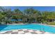 Inviting community pool with a checkered deck and lush landscaping at 21285 Holmes Cir, Venice, FL 34293