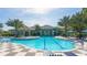 Community pool with a large deck and surrounding palm trees at 21285 Holmes Cir, Venice, FL 34293