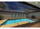 Enclosed rectangular pool with a glass ceiling and a small cart at 3902 Glen Oaks Manor Dr, Sarasota, FL 34232