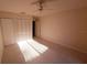 Bedroom features neutral carpet, ceiling fan, and a closet with louvered doors at 5027 Kestral Park Dr # 64, Sarasota, FL 34231