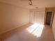 Spacious bedroom with neutral carpet, fan, and a closet with louvered doors at 5027 Kestral Park Dr # 64, Sarasota, FL 34231