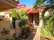 Covered front porch with brick pathway, tropical foliage and front door access at 5027 Kestral Park Dr # 64, Sarasota, FL 34231