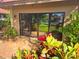Sliding glass door opens onto a courtyard with colorful foliage and a picturesque pond view at 5027 Kestral Park Dr # 64, Sarasota, FL 34231