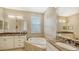 Elegant bathroom with double sinks, marble countertops, and a large soaking tub at 12663 Fontana Loop, Bradenton, FL 34211