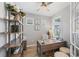 Bright home office features a built-in desk, shelving, and window with plantation shutters at 10646 Spring Tide Way, Parrish, FL 34219