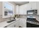 Modern kitchen features white cabinets, quartz countertops, and a stylish backsplash at 10646 Spring Tide Way, Parrish, FL 34219