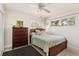 Bright bedroom featuring neutral walls, tile floors, wood dresser, and natural light from two windows at 2522 Fruit Tree Dr, Sarasota, FL 34239