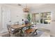 Bright dining area with a wooden table, bench, and modern light fixture with view outside at 2522 Fruit Tree Dr, Sarasota, FL 34239