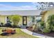 Inviting front entrance featuring a black door, decorative plants, and a cozy chair on the porch at 2522 Fruit Tree Dr, Sarasota, FL 34239