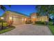 Tan single-story house with a three-car garage and manicured lawn at 14717 Leopard Creek Pl, Lakewood Ranch, FL 34202