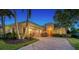 Attractive single-story home with a brick driveway and landscape lighting at 14717 Leopard Creek Pl, Lakewood Ranch, FL 34202