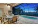 Outdoor kitchen and dining area adjacent to a screened pool at 14717 Leopard Creek Pl, Lakewood Ranch, FL 34202